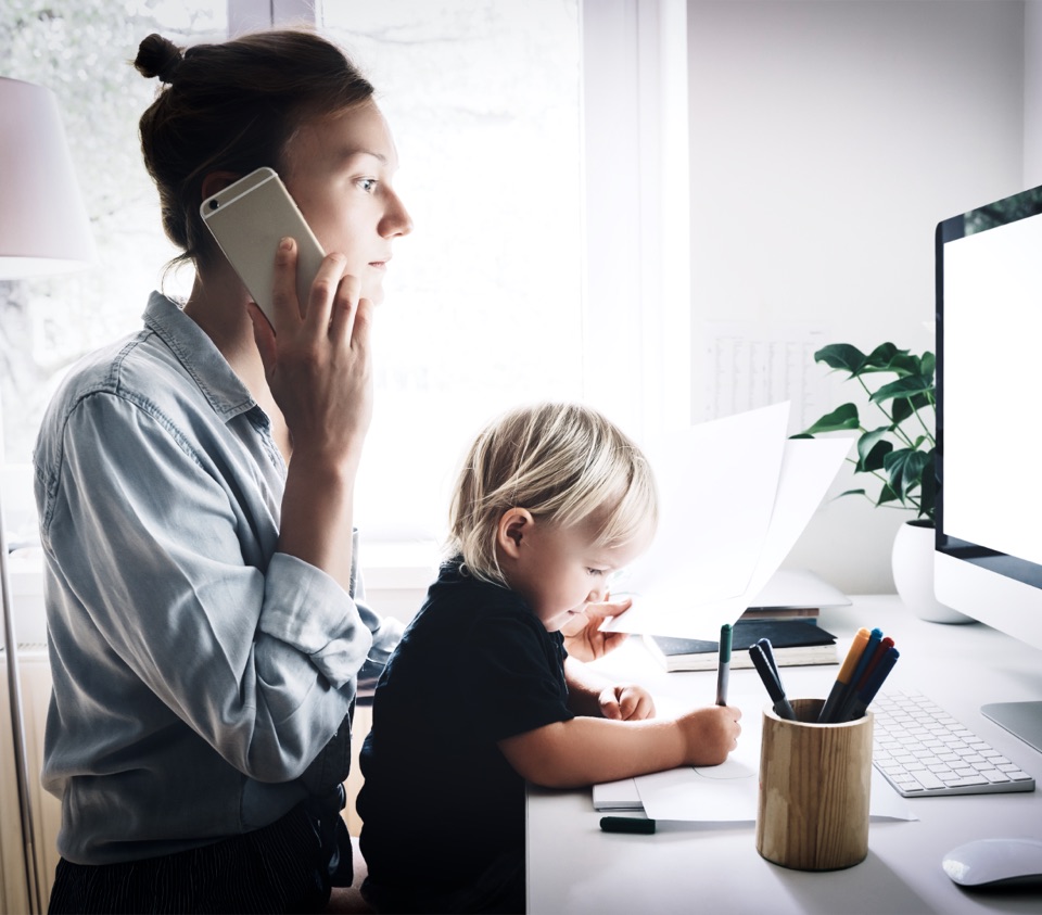 A parent managing a call and a child at the same desk
