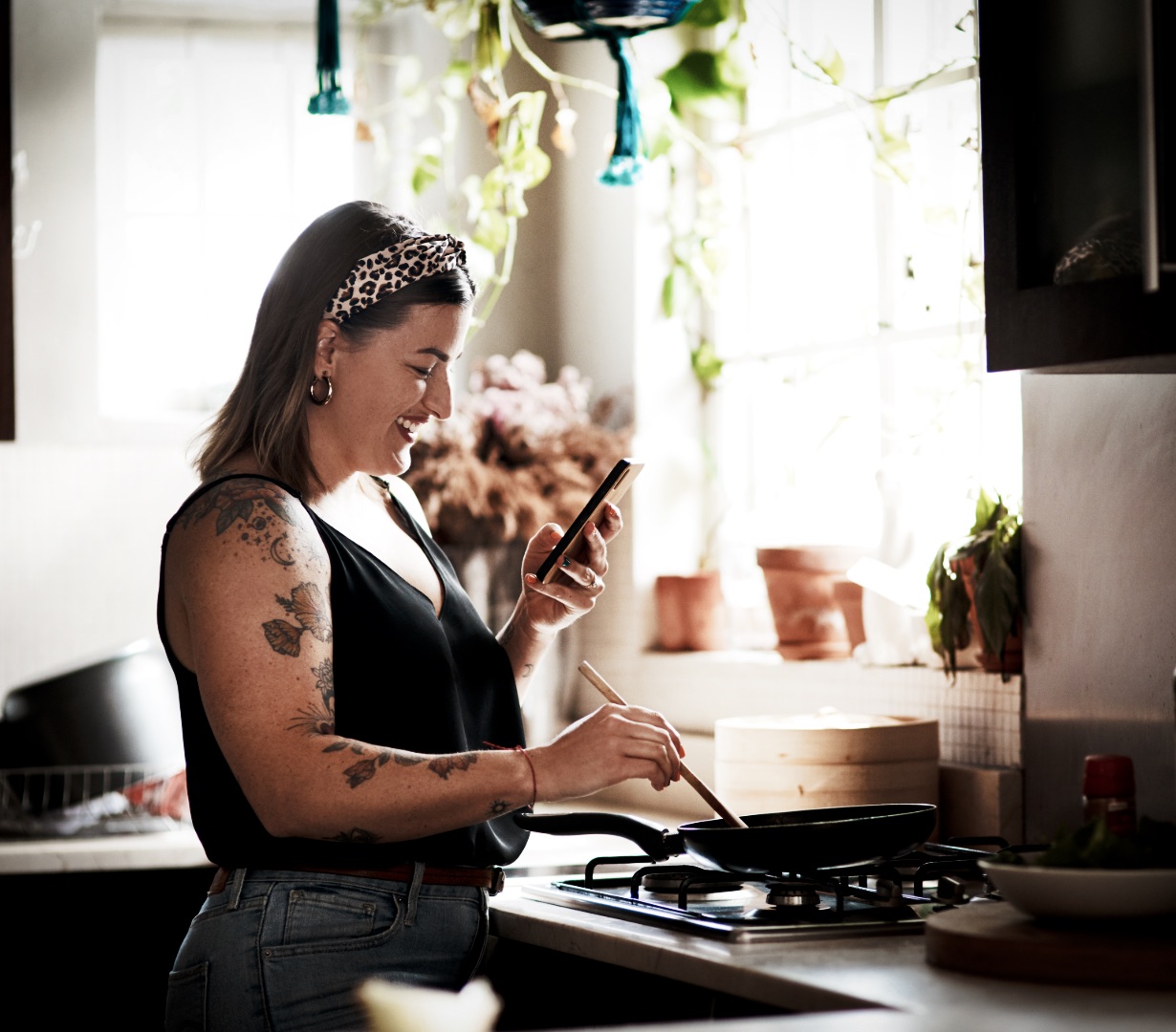 A parent checking their phone while cooking, keeping the day on track
