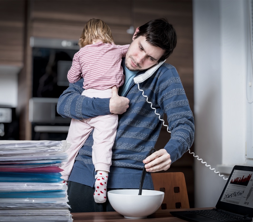 A parent juggling paperwork, a phone call, and a child all at once